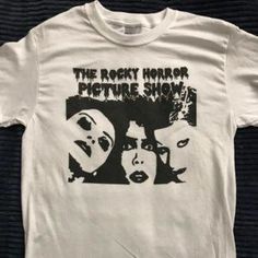 the rocky horror picture show t - shirt on a black table with an image of two women