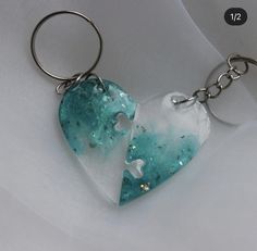 a heart shaped keychain with two pieces missing from it on a white cloth