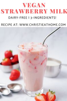 a strawberry milkshake in a glass with strawberries on the side