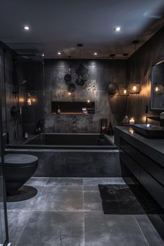 a bathroom with a large black bathtub next to a toilet and sink in it