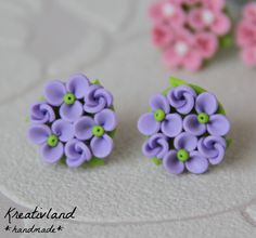 two small purple and green flowers are sitting next to each other on a white surface