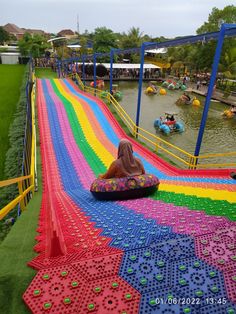 an inflatable water park with people on it and colorful mats covering the ground