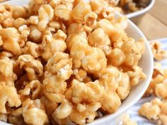 two bowls filled with caramel popcorn on top of a blue and white table cloth