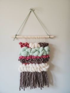 a wall hanging made out of yarn and wood