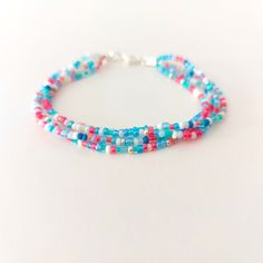 two strands of multicolored beads on a white surface