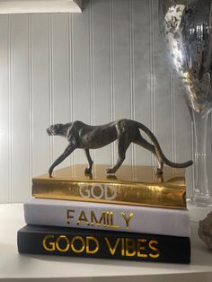 two books on top of each other with a cat figurine next to them