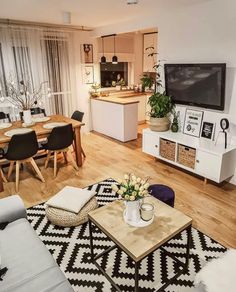 a living room filled with furniture and a flat screen tv on top of a wooden table