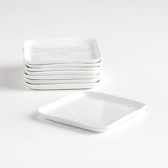 a stack of white plates sitting next to each other