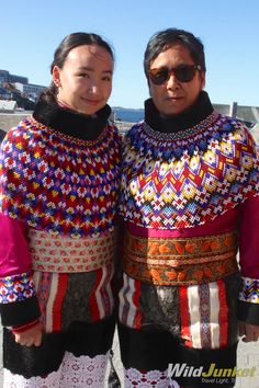 two people standing next to each other wearing colorful clothing