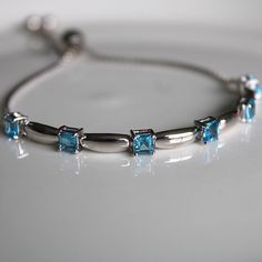 This sterling silver 3 mm Swiss Blue Topaz Gemstone Bolo Bracelet is simply elegant. She'll love the versatility this bracelet offers as it pairs amazingly with fine fashion and casual wear. The bracelet is comfortable and easy to adjust to your liking with the pull tie and ball clasp. A thoughtful gift for a December Birthday and a variety of other occasions and events. Explore All Of Our Timeless Jewelry: https://www.etsy.com/shop/JOHNWESHDESIGNS All JohnWeshDesigns jewelry is handcrafted and Cheap Blue Sterling Silver Bracelet, Adjustable Fine Jewelry Bracelets With Stones, Fine Jewelry Bracelets With Stones, Classic Silver Bracelets With Birthstone, Classic Silver Bracelet With Birthstone, Classic Silver Birthstone Bracelets, Elegant Adjustable Blue Topaz Bracelets, Elegant White Gold Bracelet With Blue Topaz, Adjustable Silver Gemstone Tennis Bracelet