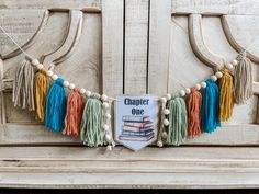 a sign with tassels hanging from it's sides on a wooden bench