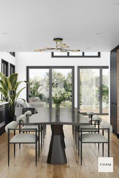 a dining room table with chairs and a potted plant in the middle of it