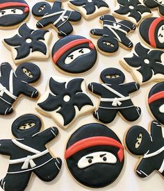 decorated cookies with black and white frosting are arranged in the shape of ninjas