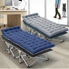 two blue and gray beds sitting on top of each other in front of a desk