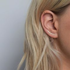 a woman with blonde hair wearing a pair of ear piercings on her left ear