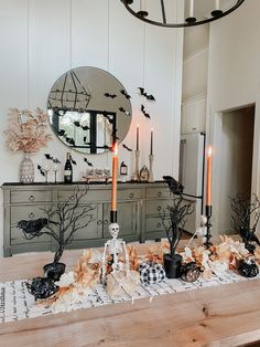 a dining room table decorated for halloween with candles and decorations