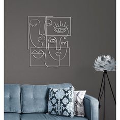 a blue couch sitting next to a wall with two faces drawn on it's side