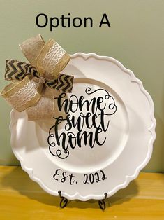 a white plate with a bow on it and the words home sweet home painted on it