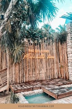 a wooden bench sitting next to a bamboo fence with the word love spelled on it