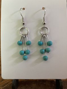 the earrings are made with silver and turquoise beads