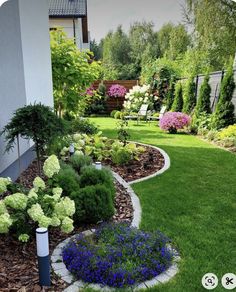 a garden with flowers and shrubs in it