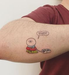 a man with a cartoon character tattoo on his arm holding a video game remote control