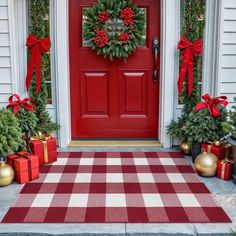 a red front door decorated for christmas with presents