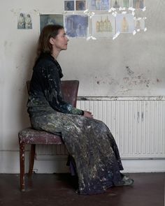 a woman sitting on a chair in front of a wall