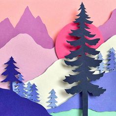 a paper cut landscape with trees and mountains in the background