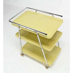 three yellow serving trays stacked on top of each other with metal handles and wheels