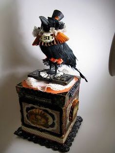 a black and orange bird sitting on top of a box with a clock in it's center