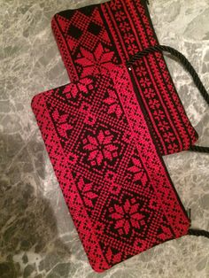 two red and black bags sitting on top of a marble counter next to each other