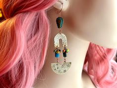 Add a touch of bohemian flair to your jewelry collection with these stunning handcrafted dangle earrings. Each pair is meticulously designed using a unique combination of raw brass, blue apatite beads, Czech glass beads, and striped seed beads. The raw brass components have been carefully hammered and hand-stamped with tiny stars, creating a fun and unique texture which is highlighted with a patina finish. The blue apatite beads bring a vibrant pop of color, while the Czech glass beads and striped seed beads add intricate detail and depth. At 4 1/8" long, these earrings make a bold statement, perfect for those who love to stand out. Their rustic feel and bohemian style make them versatile enough to complement both casual and dressy outfits. -Handcrafted just for you in my Brooklyn studio! Eclectic Adjustable Dangle Jewelry, Bohemian Beaded Earrings With Colorful Beads, Bohemian Beaded Dangle Earrings, Artsy Dangle Jewelry For Festivals, Nickel Free Artsy Jewelry For Festivals, Unique Festival Earrings With Dangling Beads, Unique Colorful Beaded Earrings, Bohemian Beaded Dangling Earrings, Eclectic Handmade Festival Jewelry