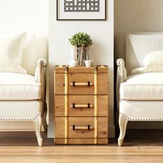 two white chairs sitting next to each other in front of a wooden dresser with drawers