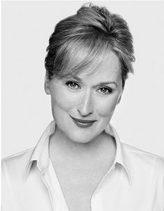 a black and white photo of a woman with short hair wearing a button up shirt