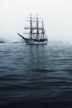 a ship sailing in the ocean on a foggy day