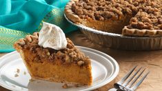 a slice of pumpkin pie on a plate with a fork and napkin next to it