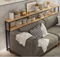 a living room filled with furniture and decor on top of a wooden shelf above a gray couch