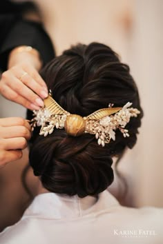 a woman is getting her hair done with a comb