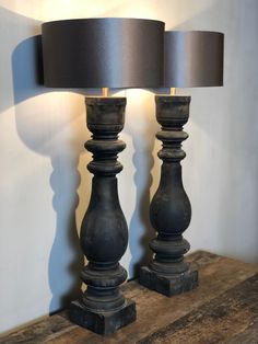 two black lamps sitting on top of a wooden table