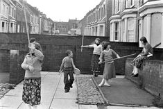 black and white photograph of children playing on sidewalk