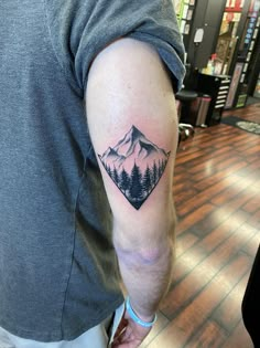 a man with a mountain tattoo on his arm