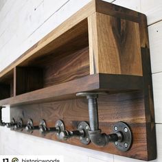 an industrial style wooden shelf with metal pipe handles and brackets on the wall above it