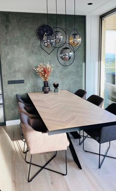 a dining room table with chairs and hanging lights