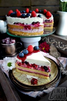 there is a piece of cake with berries on it and another slice has raspberries