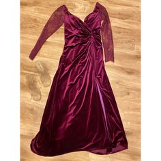 a purple dress laying on top of a wooden floor