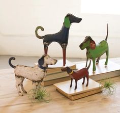 three dog figurines sitting on top of books