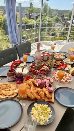 a table filled with food and drinks on top of a white table covered in blue plates