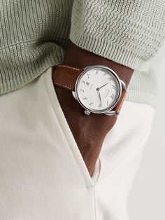 Our Senior Watches Editor, Mr Chris Hall, says that a dress watch should be simple, elegant and slim enough to sit beneath a shirt cuff, which is the case for Hermès Timepieces' 'Arceau' reference. Designed with a signature Barenia leather strap, it has a rounded 40mm polished stainless steel case that houses a herringbone-detailed dial with italicised Arabic numerals and a date window. The oscillating weight, on show through the exhibition case back, is stamped with the house's initial. We off… White Watches For Men, Hermes Watch, Titanium Watches, Latest Watches, Shirt Cuff, Classic Watches, Dress Watch, Mens Luxury, The Exhibition