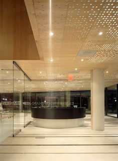 an empty room with a circular table in the center and lots of lights on the ceiling